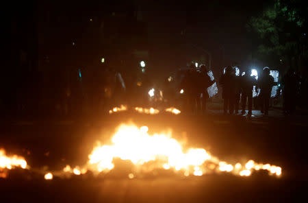 Riot policemen walk past a barricade on fire after a clash with anti-government demonstrators during a strike against Brazilian social welfare reform project, in Rio de Janeiro, Brazil, March 15, 2017. REUTERS/Ricardo Moraes