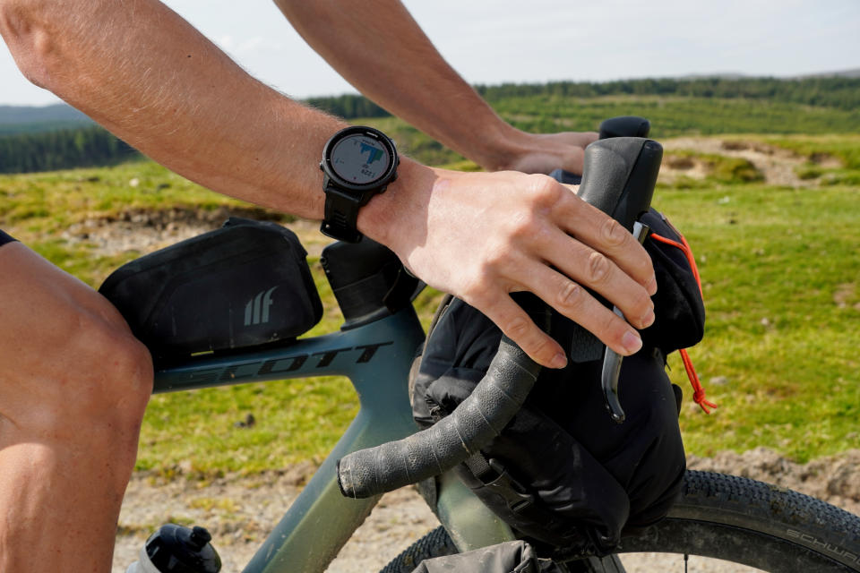 Male cyclist riding wearing the Garmin Forerunner 955 Solar