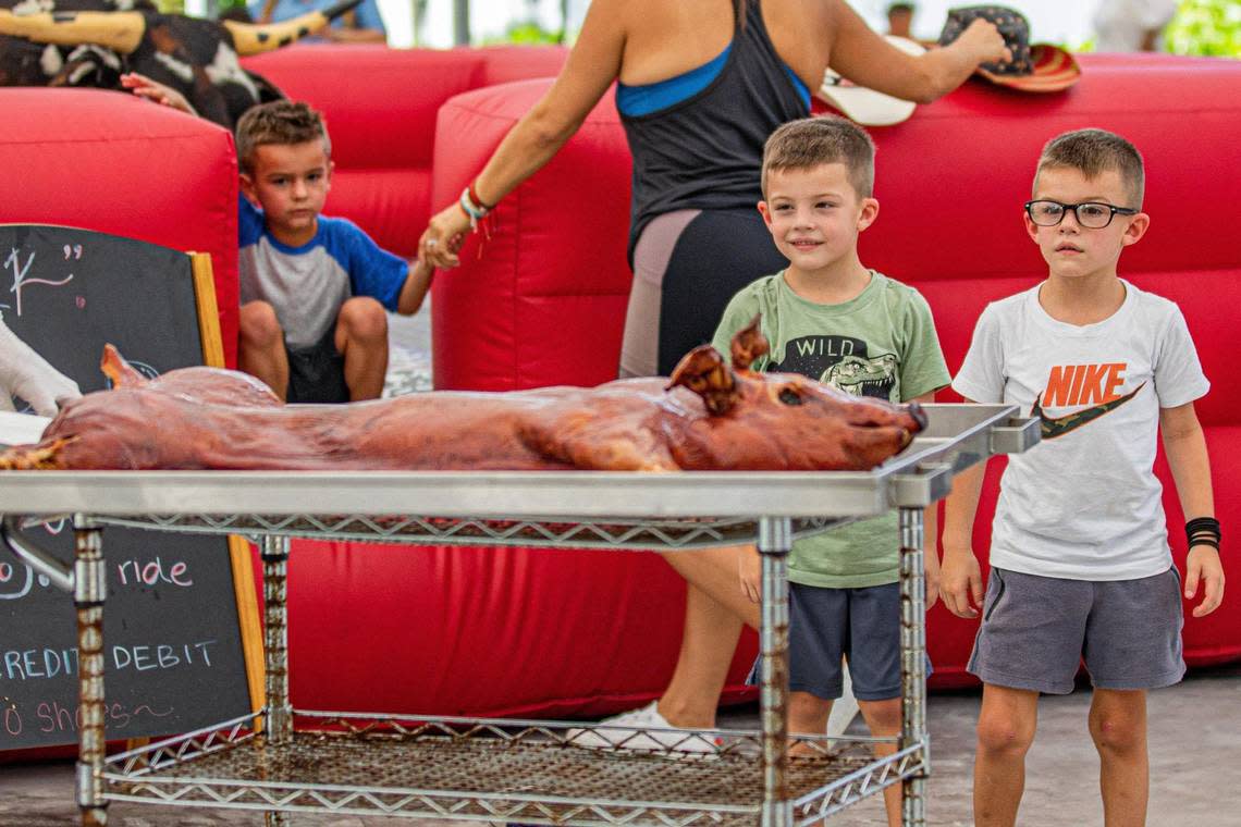 Children watch as a whole roasted pig is brought out by founder and wwner Royd Lemus at Royd’s.