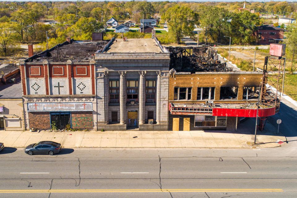 Aerial view of a damaged building with a burnt roof next to an intact building