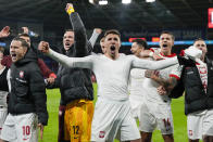 Poland players celebrate after defeating Wales in a penalty shoot out during their Euro 2024 soccer play-off match at Cardiff City Stadium, Wales, Tuesday, March 26, 2024. (AP Photo/Alastair Grant)