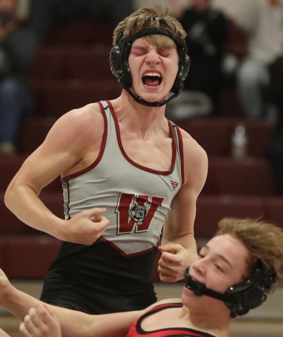 Woodridge 120-pound wrestler Corey Casterline celebrates one of his two pints in the Bulldogs' victories over Springfield and Coventry on Thursday. [Mike Cardew/Beacon Journal]