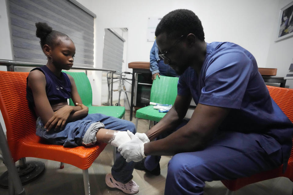 A prosthetist molds a cast for Princess Igbinosa, 10, who lost her leg following a traffic accident in Lagos, Nigeria, Thursday, Nov. 30, 2023. Princess can now walk, thanks to an artificial limb from the IREDE Foundation, a group providing children like her with free prosthetics and helping their families offset the average cost of $2,000 to $3,000. (AP Photo/Sunday Alamba)