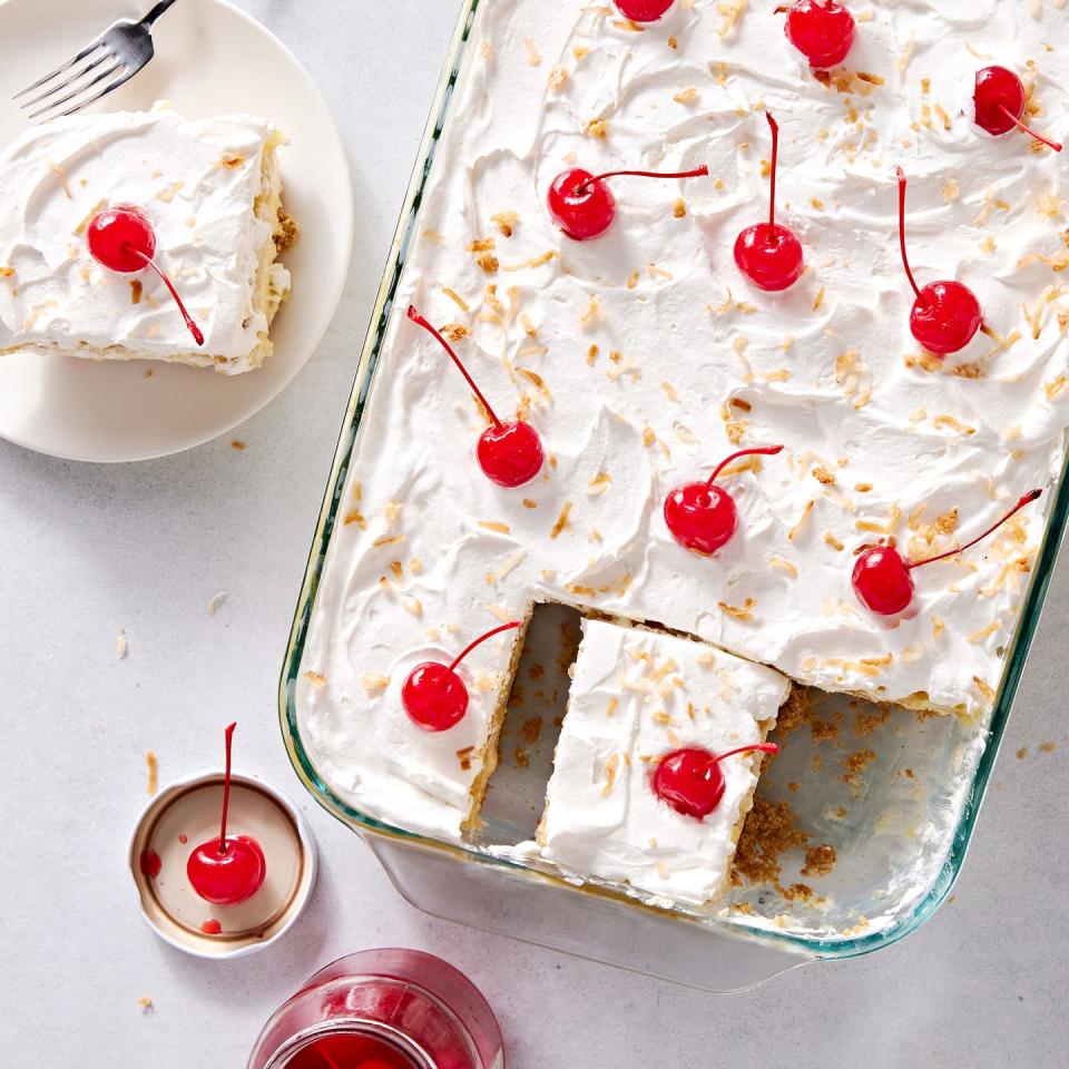 creamy coconut lime cheesecake layered with buttery shortbread cookies, crushed pineapple jello, cool whipped cream, and maraschino cherries all on a graham cracker coconut crust