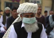 An Afghan Muslim man wearing a face mask as a precaution against coronavirus offers Eid al-Adha prayers in Kabul, Afghanistan, Friday, July 31, 2020. Muslims worldwide marked the the Eid al-Adha holiday over the past days amid a global pandemic that has impacted nearly every aspect of this year's celebrations. (AP Photo/Rahmat Gul)