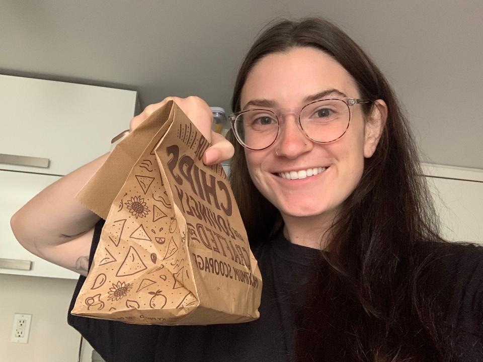 The author holds a bag of Chipotle chips.