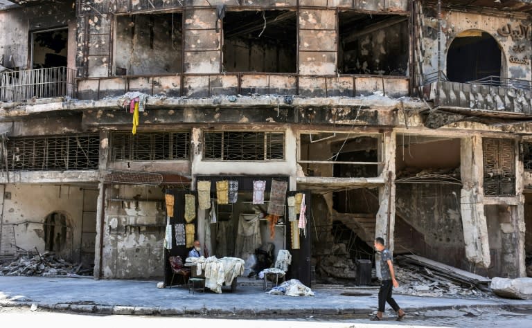 Mohammad Shawash sits outside his shop in the devastated streets of Aleppo's old city on July 22, 2017