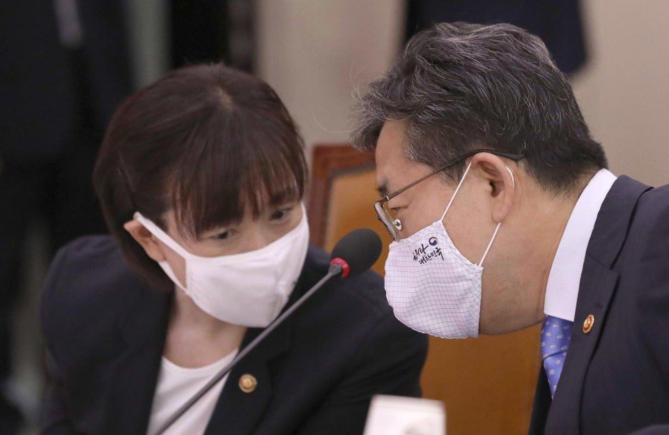 Park Yang-woo, right, minister of the Ministry of Culture, Sports and Tourism, talks with Choi Yoon-hee, left, vice minister of the Ministry of Culture, Sports and Tourism during a parliamentary committee meeting at the National Assembly in Seoul, South Korea, Monday, July 6, 2020. Top South Korean officials on Monday offered a public apology and vowed to delve into the death of a triathlete who had reported to government and sports bodies that she had been abused her team coach, physical therapist and colleagues. (Kim Sun-woong/Newsis via AP)