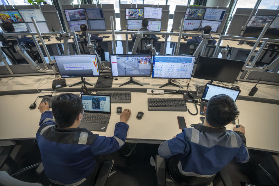 Workers use computer terminals to monitor remote operations at a container port in Tianjin, China, on Jan. 16, 2023. As technicians in a distant control room watch on display screens, an automated crane at one of China's busiest ports moves cargo containers from a Japanese freighter to self-driving trucks in a scene Chinese tech giant Huawei sees as its future after American sanctions crushed its smartphone brand. (AP Photo/Mark Schiefelbein)