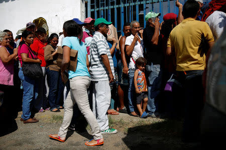 Zulay Pulgar (C), 43, stands in line outside a hardware store, next to her son Emmanuel, 4, to buy cement and resell it in Punto Fijo, Venezuela November 17, 2016. Picture taken November 17, 2016. REUTERS/Carlos Garcia Rawlins