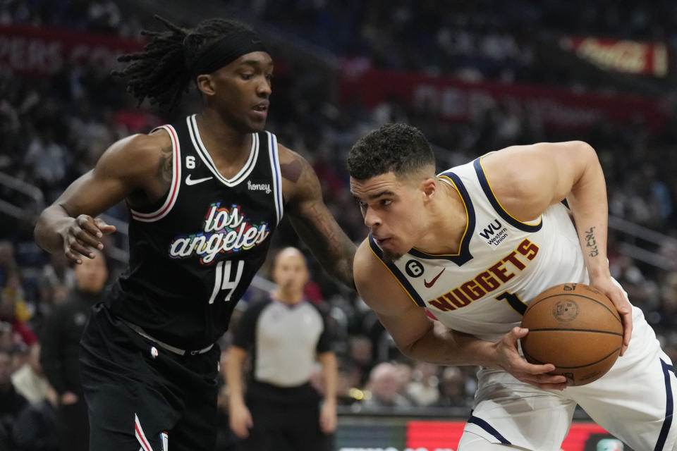 Denver Nuggets forward Michael Porter Jr., right, is defended by Los Angeles Clippers guard Terance Mann (14) during the second half of an NBA basketball game Friday, Jan. 13, 2023, in Los Angeles. (AP Photo/Marcio Jose Sanchez)