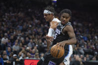 Sacramento Kings guard Davion Mitchell (15) takes the ball away from Orlando Magic forward Paolo Banchero, left, in the first quarter in an NBA basketball game in Sacramento, Calif., Monday, Jan. 9, 2023. (AP Photo/José Luis Villegas)