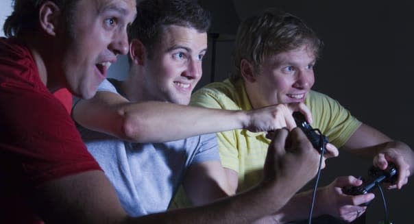 Three men playing a games console