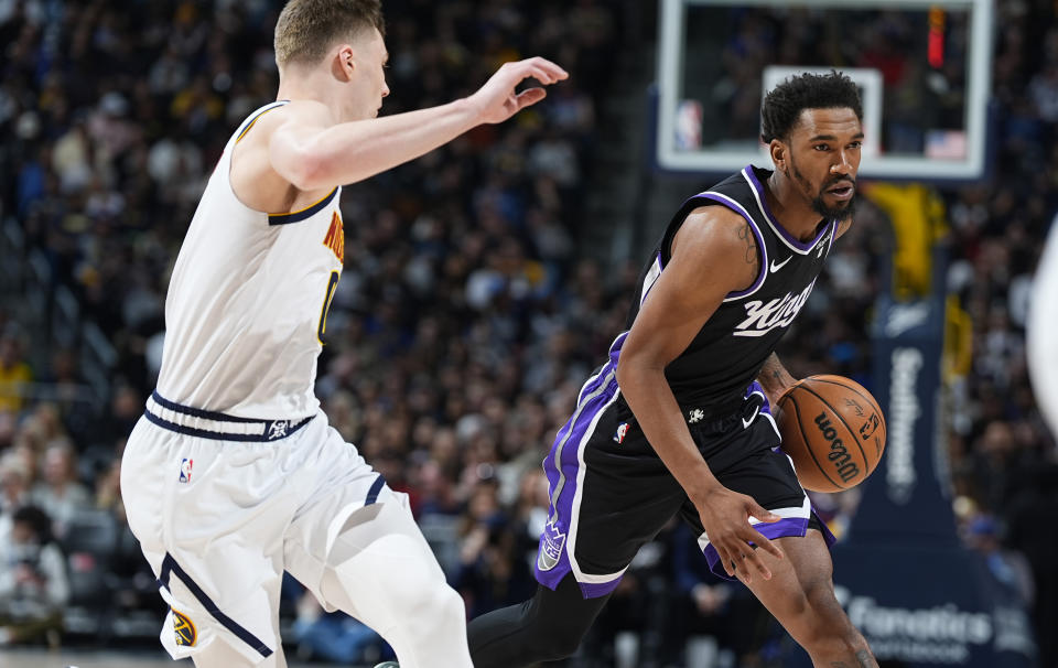 Sacramento Kings guard Malik Monk, right, drives past Denver Nuggets guard Christian Braun during the first half of an NBA basketball game Wednesday, Feb. 28, 2024, in Denver. (AP Photo/David Zalubowski)