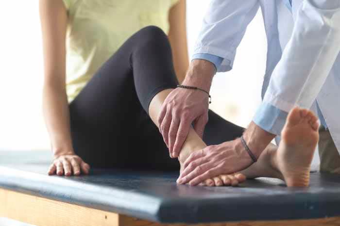 mujer en el médico con dolor en el tobillo