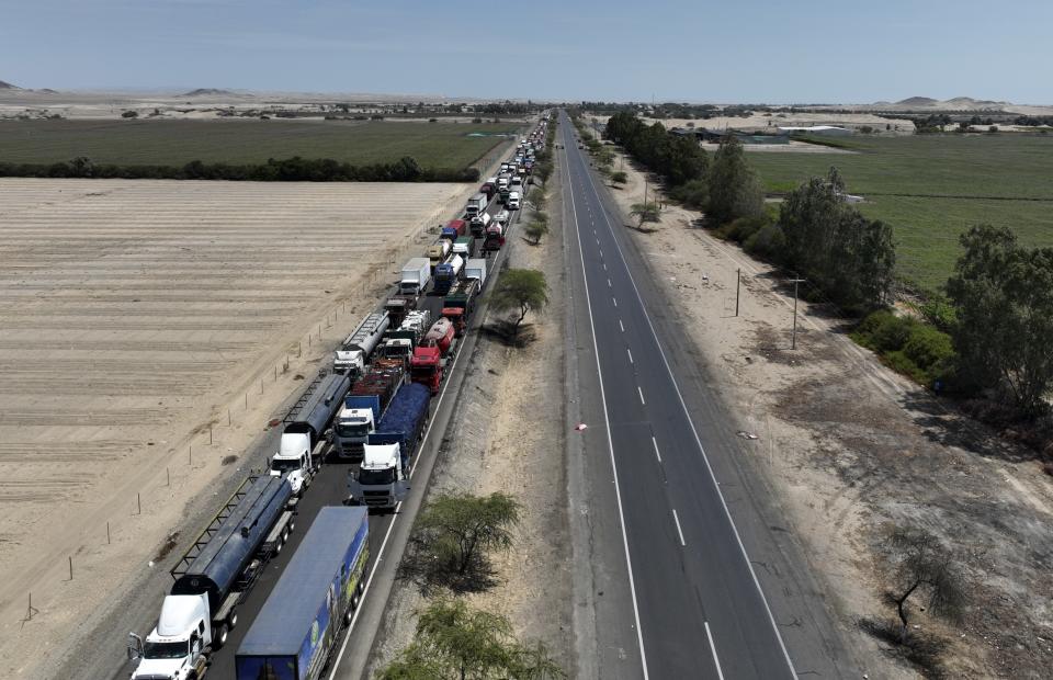 Trucks block the Pan American highway during a truckers strike in Ica, Peru, Tuesday, April 5, 2022. Peru's President Pedro Castillo imposed a curfew on the capital and the country's main port in response to sometimes violent protests over rising prices of fuel and food, requiring people in Lima and Callao to mostly stay in their homes all of Tuesday. (AP Photo/Guadalupe Pardo)