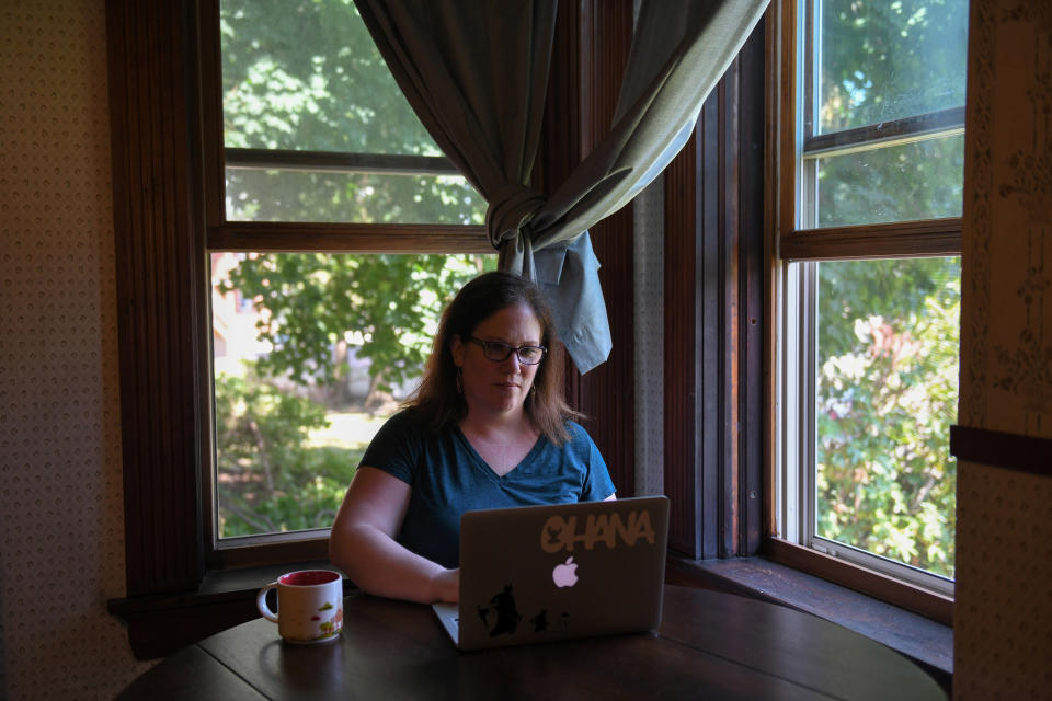 Amanda Geno, who has been unemployed since mid-March due to the global outbreak of the coronavirus disease (COVID-19), but has been able to keep paying her rent and other bills largely because of enhanced unemployment benefits enacted under the CARES Act, works on her laptop at home in Holyoke, Massachusetts, United States August 5, 2020.  Picture taken August 5, 2020.  REUTERS/Faith Ninivaggi