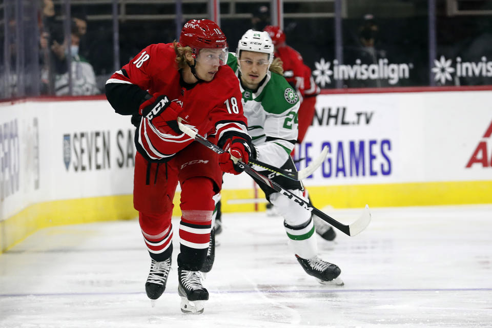 Carolina Hurricanes' Ryan Dzingel (18) passes the puck as he is approached by Dallas Stars' Roope Hintz (24) during the first period of an NHL hockey game in Raleigh, N.C., Sunday, Jan. 31, 2021. (AP Photo/Karl B DeBlaker)