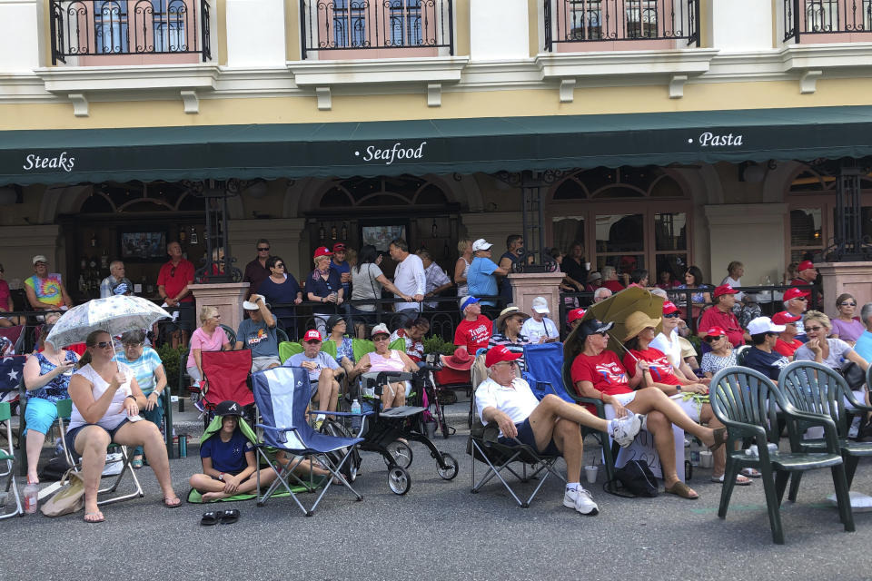 FILE - In this Oct. 3, 2019 file photo, supporters of President Donald Trump wait outside in a town square in The Villages, Fla., before an appearance by the president. There has always been a low-boil tension in The Villages between the Republican majority and the much smaller cohort of Democrats, but a veneer of good manners in “Florida's Friendliest Hometown" mostly prevailed on golf courses and at bridge tables. Those tensions got international attention last weekend when President Donald Trump tweeted approvingly of a video showing one of his supporters at the retirement community chanting a racist slogan associated with white supremacists. (AP Photo/Mike Schneider, File)