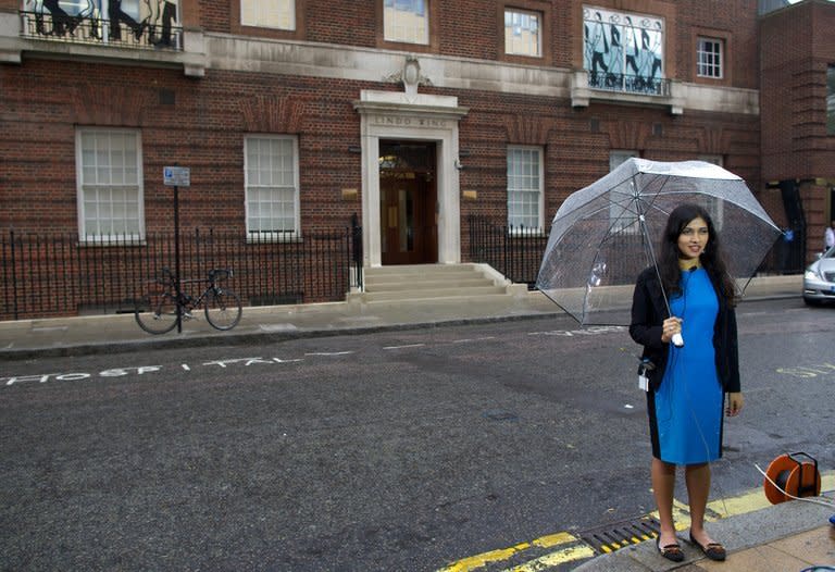 A reporter prepares to go on camera outside the Lindo Wing at St Mary's Hospital in London on June 20, 2013. Prince William's wife Catherine is not officially due to give birth for two weeks but the world's media began gathering outside the London hospital where she will have the baby, determined not to miss the photograph of the year