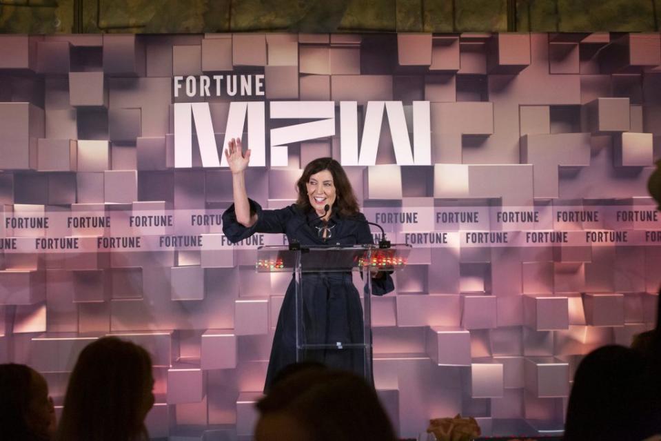 New York Governor Kathy Hochul standing in front of a geometric backdrop and behind a lectern.