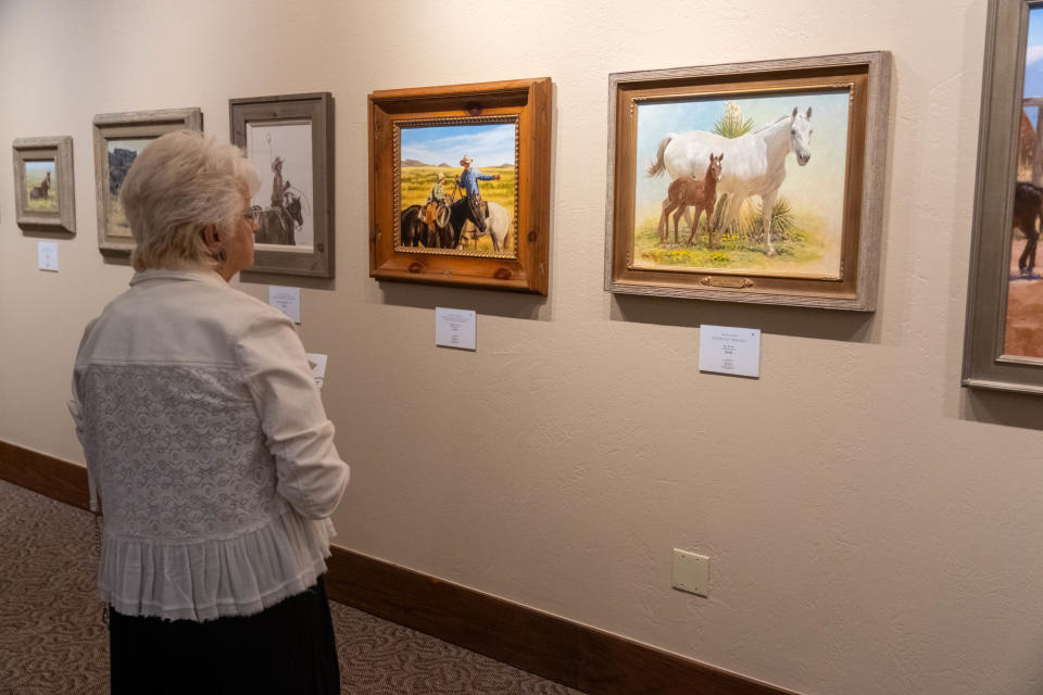 An onlooker admires the artwork at the 15th annual AQHA Art Show on Aug. 12 in Amarillo.