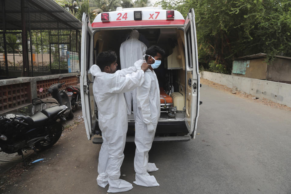 Izhaar Hussain Shaikh, right, an ambulance driver who works for HelpNow, an initiative to help the stretched services of first responders, is assisted by his helper to wear the face mask before picking up a COVID-19 patient in Mumbai, India May 28, 2020. It’s an exhausting job and Shaikh's daily shifts are grueling, sometimes even stretching to 16 hours. For a city that has a history of shortage of ambulances and where coronavirus pandemic has claimed hundreds of lives, putting the health care system under immense strain, every help counts. (AP Photo/Rafiq Maqbool)