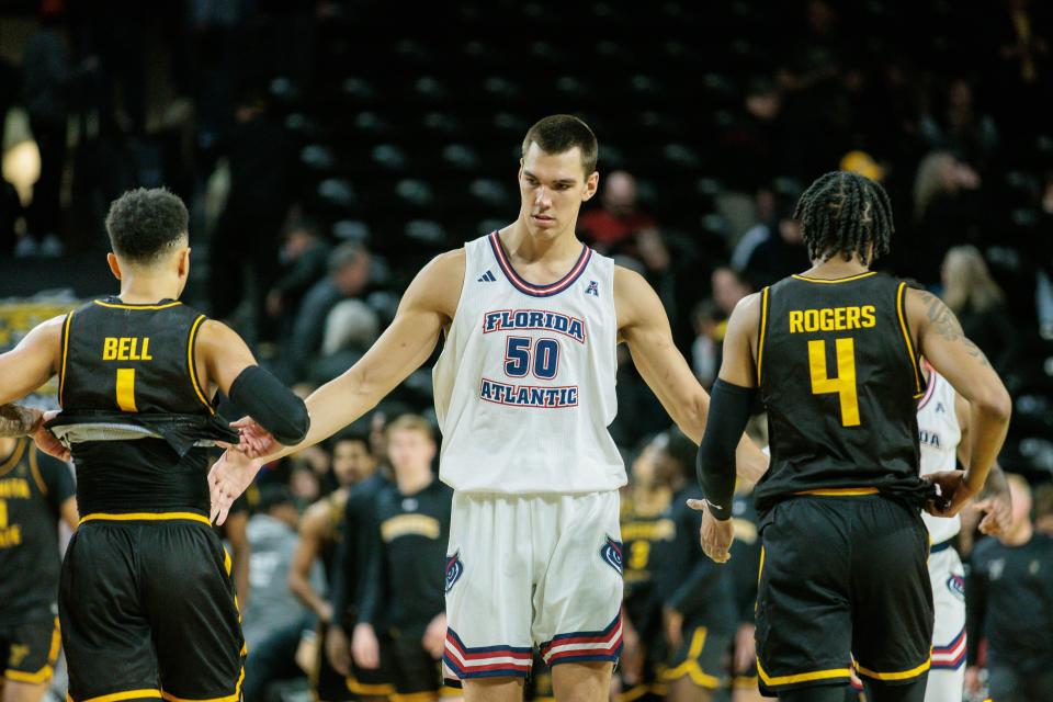 Feb 11, 2024; Wichita, Kansas, USA; Florida Atlantic Owls center Vladislav Goldin (50) slaps hands with Wichita State Shockers guard Xavier Bell (1) and Wichita State Shockers guard Colby Rogers (4) after the game at Charles Koch Arena. Mandatory Credit: William Purnell-USA TODAY Sports