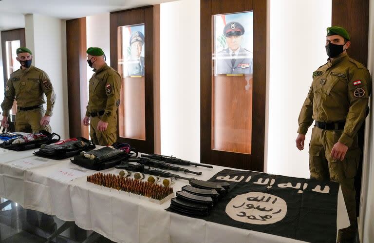 Elementos de las fuerzas especiales de la policía libanesa junto a una mesa donde se exhiben una bandera del grupo Estado Islámico.