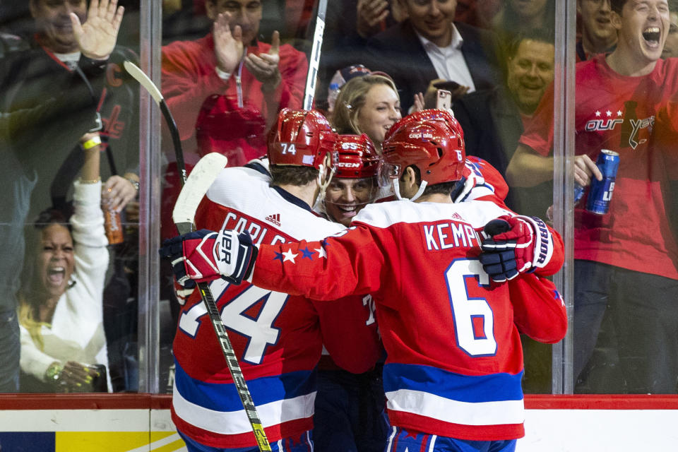 Washington Capitals left wing Andre Burakovsky (65), of Austria, is hugged by John Carlson (74) and Michal Kempny (6), of the Czech Republic, during the third period of an NHL hockey game, Friday, Nov. 30, 2018, in Washington. The Capitals won 6-3. (AP Photo/Al Drago)