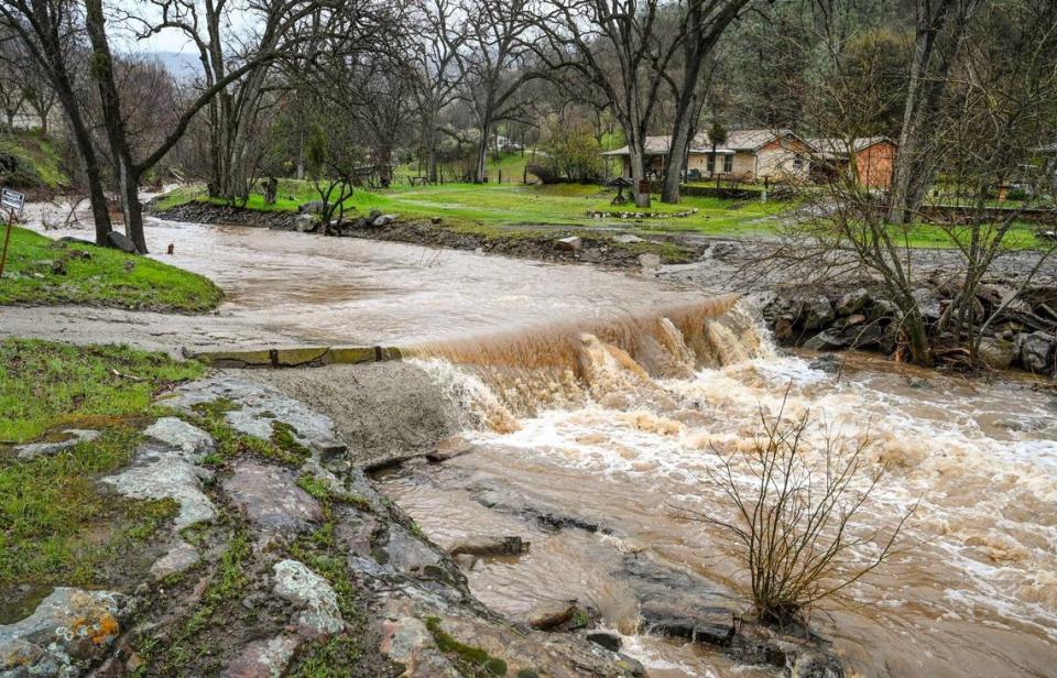 Water flows over a bridge on the Coarse Gold Creek in Coarsegold in Madera County during a rainstorm on Tuesday, March 14, 2023.