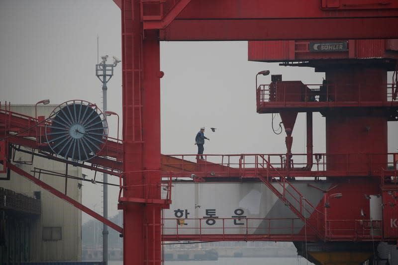 An employee walks on a crane at a container terminal at Incheon port in Incheon