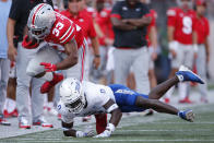 Tulsa defensive back Tyon Davis, bottom, tackles Ohio State running back Master Teague (33) during the first half of an NCAA college football game Saturday, Sept. 18, 2021, in Columbus, Ohio. (AP Photo/Jay LaPrete)