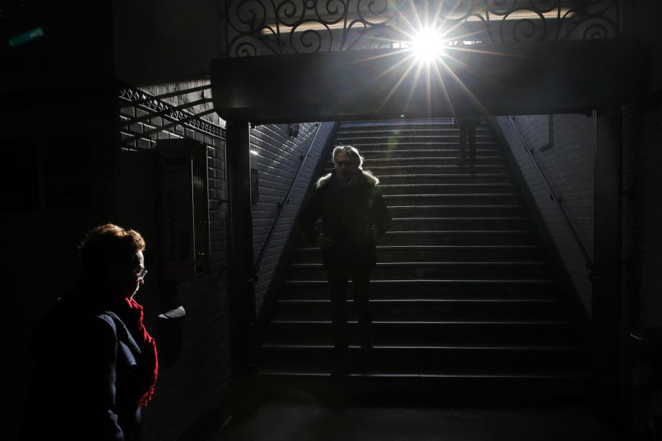 Commuters enter the Paris subway during a minimal strike, in Paris, Monday, Feb. 17, 2020. Emmanuel Macron's divisive reform on pensions is making its way to be debated by lawmakers at the lower house of parliament, the National Assembly, on Monday in a process that could take months. (AP Photo/Christophe Ena)