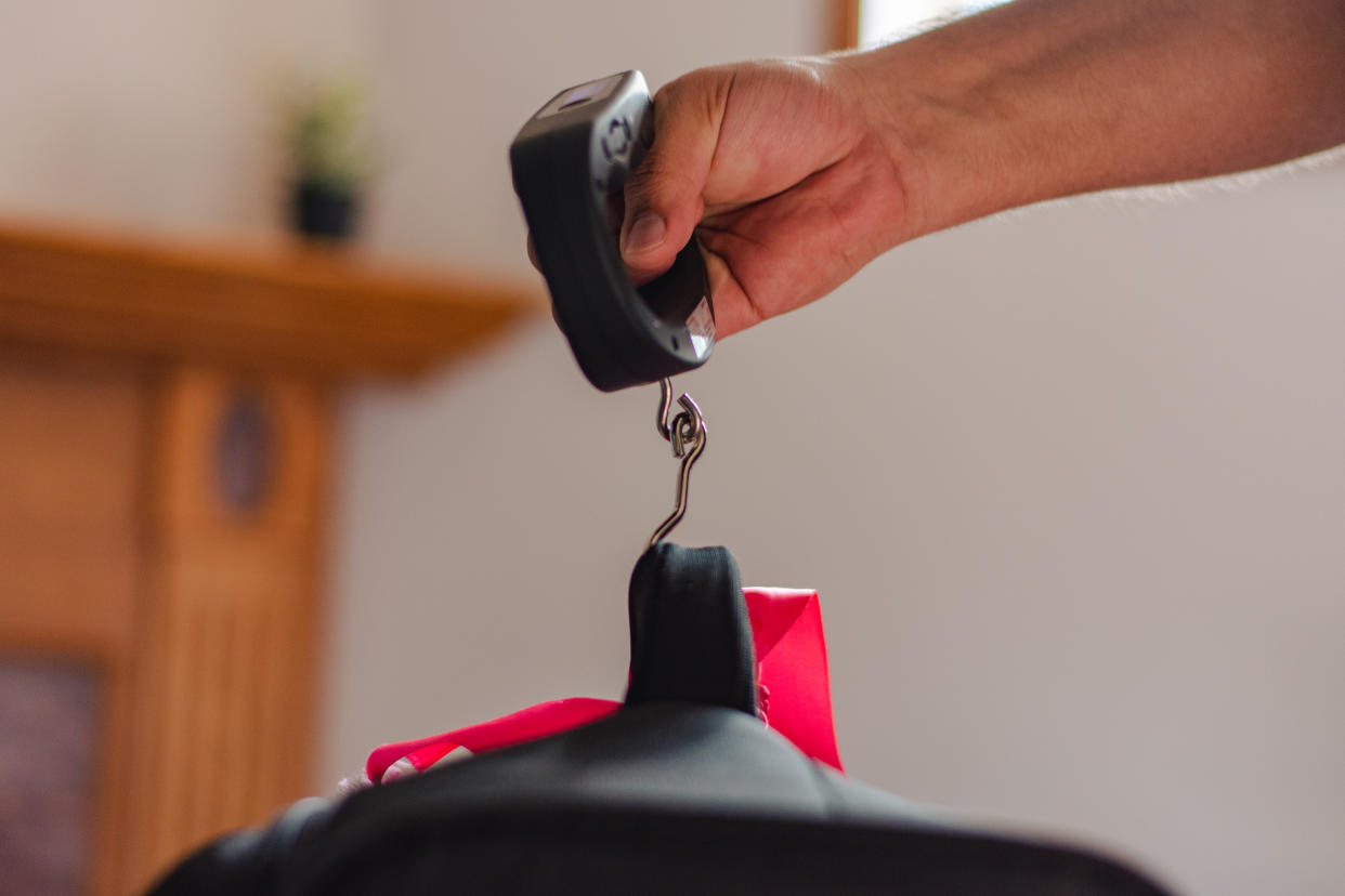 POV of human hand weighting the suitcase at home on London, Ontario, Canada