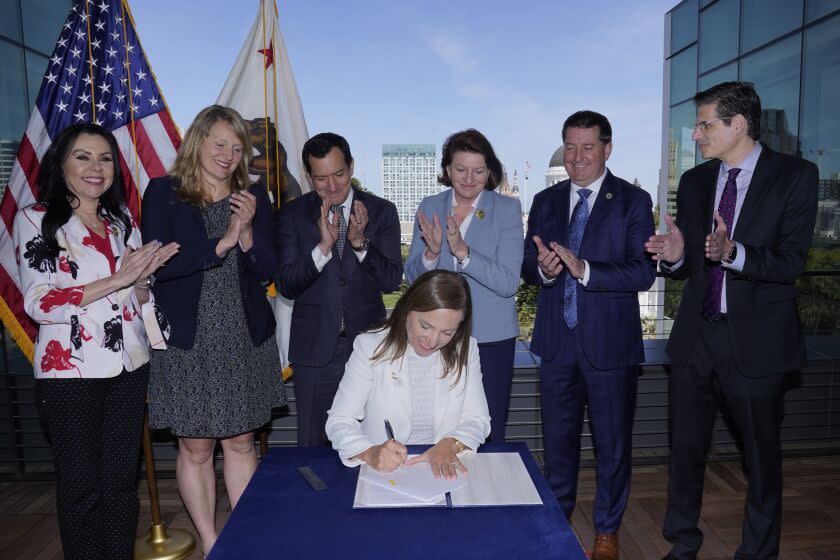 California Lt. Gov. Eleni Kounalakis signs a law to extend eviction protections in California on Thursday, March 31, 2022, in Sacramento, Calif. The law will stop people from being evicted from their homes through June 30 as long as they have applied for state assistance. Kounalakis is acting governor while Gov. Gavin Newsom is out of the state on a family vacation. She is the first woman in California history to sign a bill into law. Standing are Democratic lawmakers from left to right Assembly members Blanca Rubio, Buffy Wicks, Assembly Speaker Anthony Rendon, Senate President Pro Tempore Toni Atkins, Assemblyman Tim Grayson and Sen. Josh Becker. (AP Photo/Rich Pedroncelli)