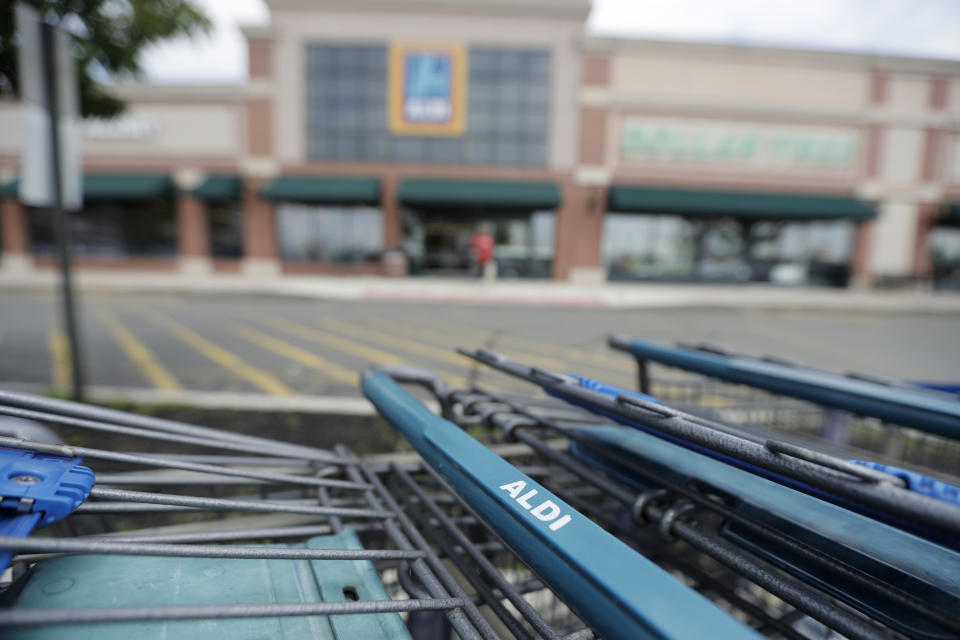 Shopping carts are lined up on the parking lot of an Aldi supermarket