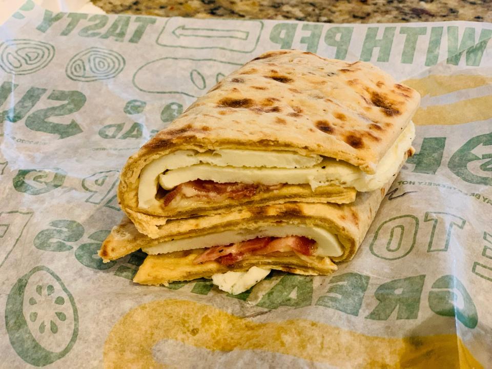 Subway's bacon, egg, and cheese sandwich split in half on wrapper