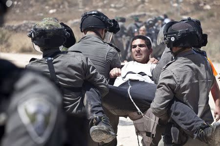 Israeli paramilitary police detain a Jewish settler protesting the demolition of two partially-built dwellings in the West Bank Jewish settlement of Beit El near Ramallah July 29, 2015. REUTERS/Emil Salman