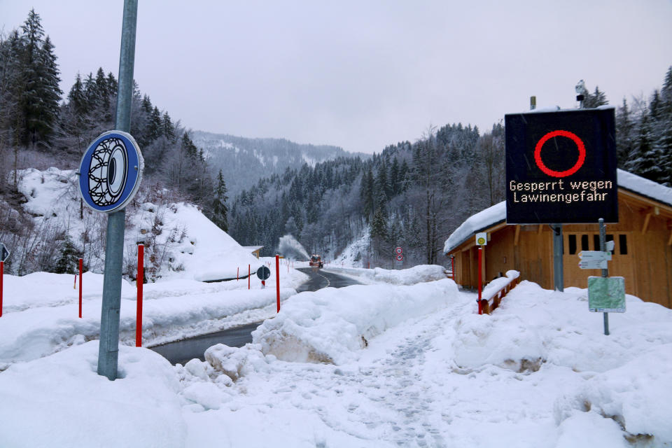 A snow plough clears a street to Balderschwang which is closed to the public due to the risk of avalanches in Obermaiselstein, southern Germany, Monday, Jan. 14, 2019. (Benjamin Liss/dpa via AP)