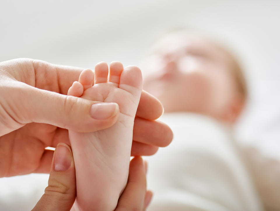 Hands examining an infants foot