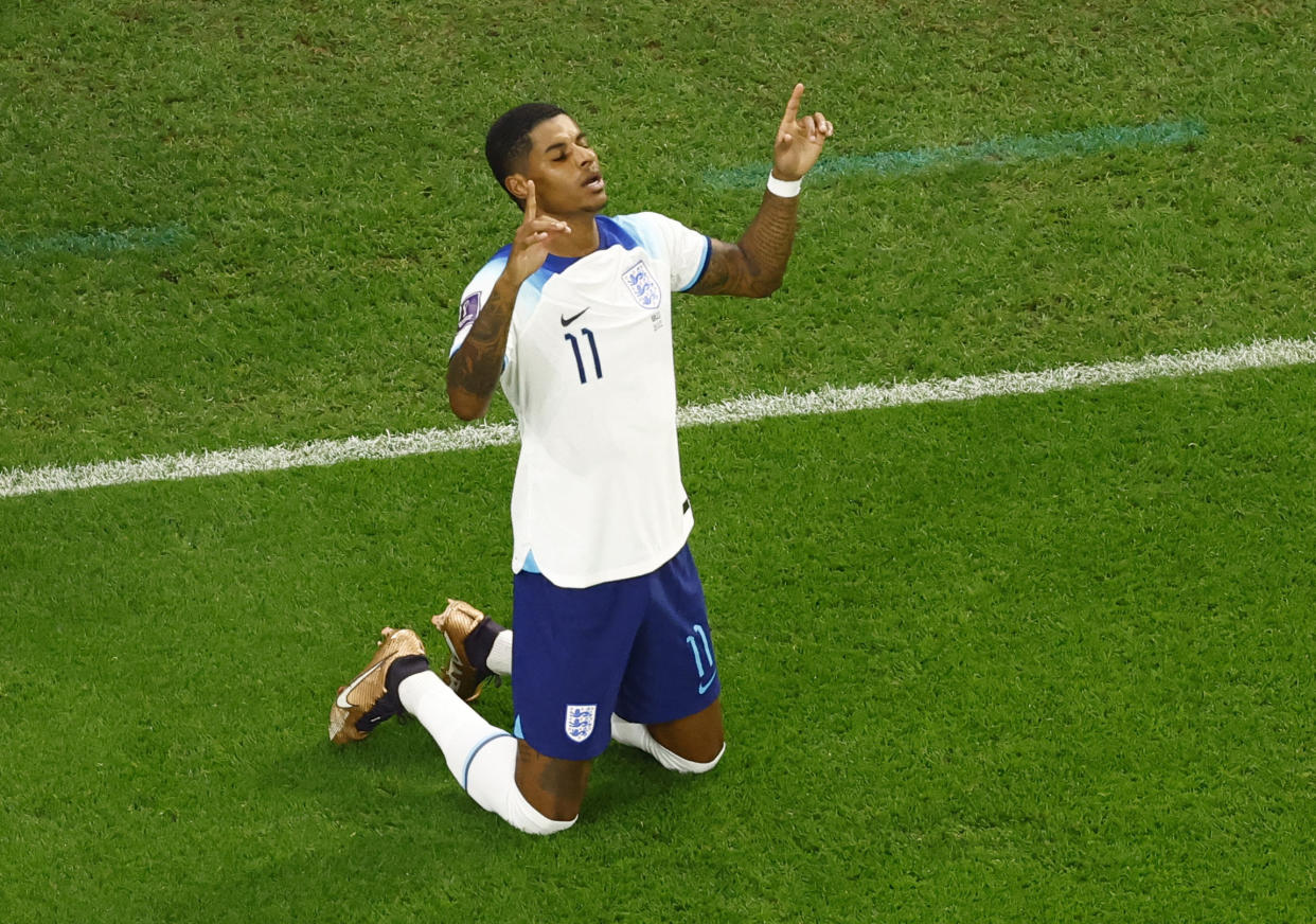 England's Marcus Rashford kneels to the ground to celebrate scoring against Wales at the World Cup. 