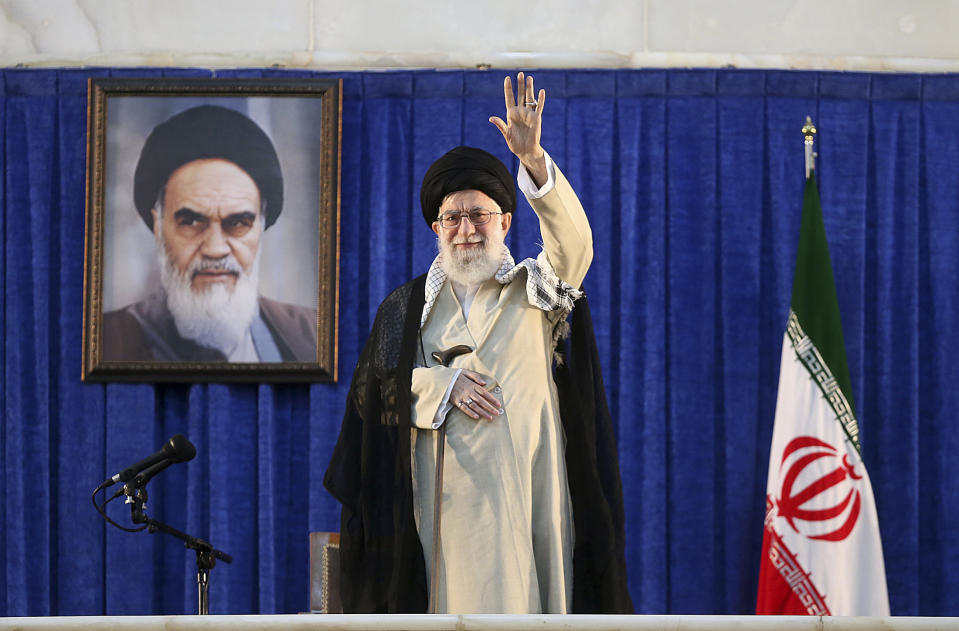 In this picture released by the official website of the office of the Iranian supreme leader, Supreme Leader Ayatollah Ali Khamenei waves to the crowd while attending a ceremony marking 30th death anniversary of the late revolutionary founder Ayatollah Khomeini, shown in the poster at rear, at his mausoleum just outside Tehran, Iran, Tuesday, June 4, 2019. Ayatollah Khamenei said his country will continue resisting U.S. economic and political pressure on his country. (Office of the Iranian Supreme Leader via AP)
