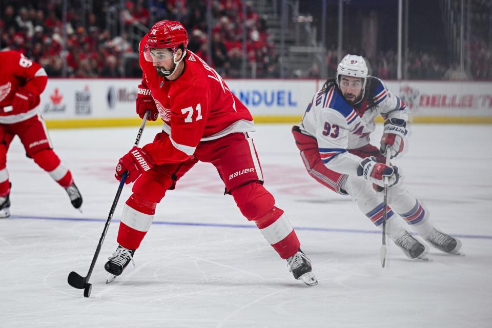 Red Wings center Dylan Larkin brings the puck up ice against Rangers center Mika Zibanejad during the second period of the Wings' 4-3 loss on Friday, April 5, 2024, at Little Caesars Arena.