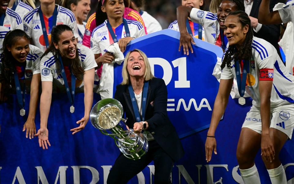 Sonia Bompastor lifts the trophy as she celebrates with her players after Lyon were crowned French Women's D1 Champions