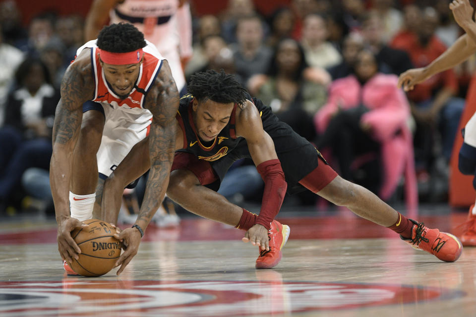 Cleveland Cavaliers guard Darius Garland, right, and Washington Wizards guard Bradley Beal reach low for the ball during the second half of an NBA basketball game Friday, Feb. 21, 2020, in Washington. Garland was called for a foul on the play. The Cavaliers won 113-108. (AP Photo/Nick Wass)