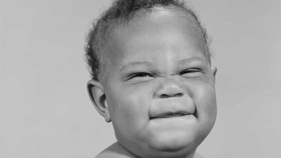 african american baby squinting eyes and scrunching up face