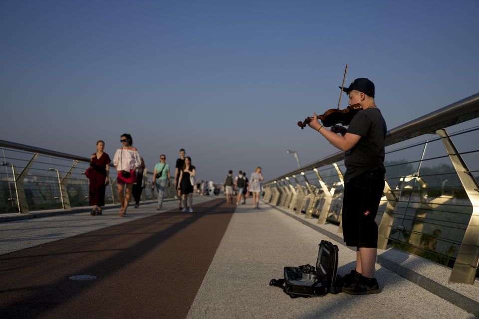 A street musician performs in Kyiv, Ukraine, Friday, June 10, 2022. With war raging on fronts to the east and south, the summer of 2022 is proving bitter for the Ukrainian capital, Kyiv. The sun shines but sadness and grim determination reign. (AP Photo/Natacha Pisarenko)