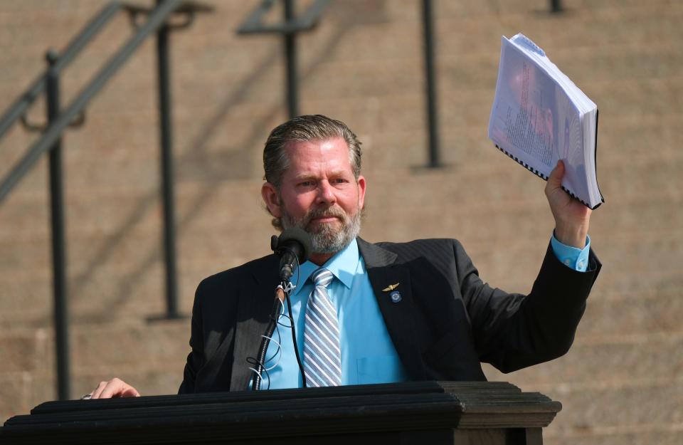 Rep. Kevin McDugle holds up a copy of an independent report Tuesday at a Justice Rally for Richard Glossip at the state Capitol.