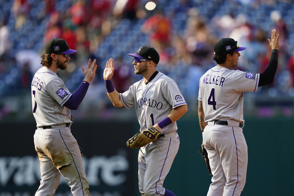 Colorado Rockies' Brendan Rodgers, from left, Garrett Hampson and Colton Welker celebrate after a baseball game against the Philadelphia Phillies, Sunday, Sept. 12, 2021, in Philadelphia. (AP Photo/Matt Slocum)